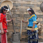 Warga berpakaian adat menunjukkan alat tumbuk padi tradisional yang dipajang di pasar produk UMKM khas Lindu di Desa Tomado, Kecamatan Lindu, Sigi, Sulawesi Tengah, Jumat (18/7/2025). (bmzIMAGES/basri marzuki)