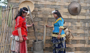 Warga berpakaian adat menunjukkan alat tumbuk padi tradisional yang dipajang di pasar produk UMKM khas Lindu di Desa Tomado, Kecamatan Lindu, Sigi, Sulawesi Tengah, Jumat (18/7/2025). (bmzIMAGES/basri marzuki)
