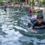 Sejumlah warga mandi di kolam permandian alam Bionga, Desa Kaleke, Sigi, Sulawesi Tengah, Sabtu (5/7/2025). Kawasan wisata alam yang dikelola oleh warga setempat dan dibuka sejak 2020 itu menjadi pilihan berlibur warga sekitarnya karena selain kejernihan air yang bersumber dari mata airnya juga karena keasrian panorama alam sekitarnya yang rimbun oleh pepohonan. (bmzIMAGES/Basri Marzuki)