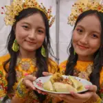 Dua remaja putri menunjukkan makanan tradisional Utadada pada festival Utadada di RTH Asmaul Husna, Binangga, Marawola, Sigi, Sabtu (20/9/2025). (©bmzIMAGES/basri marzuki)
