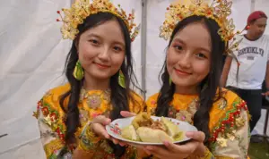 Dua remaja putri menunjukkan makanan tradisional Utadada pada festival Utadada di RTH Asmaul Husna, Binangga, Marawola, Sigi, Sabtu (20/9/2025). (©bmzIMAGES/basri marzuki)